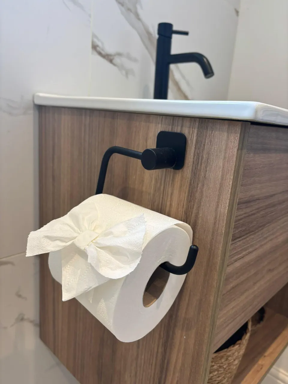 Black basin tap and wood vanity unit after a bathroom clean